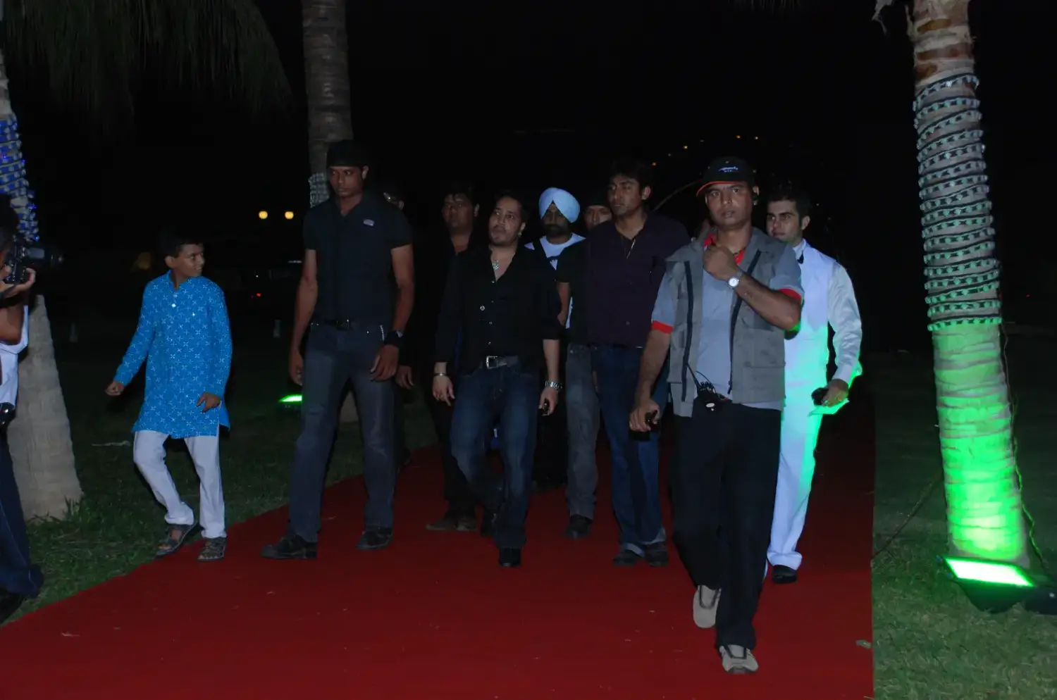 Group of men posing with large cartoon character inflatable figures at night outdoors